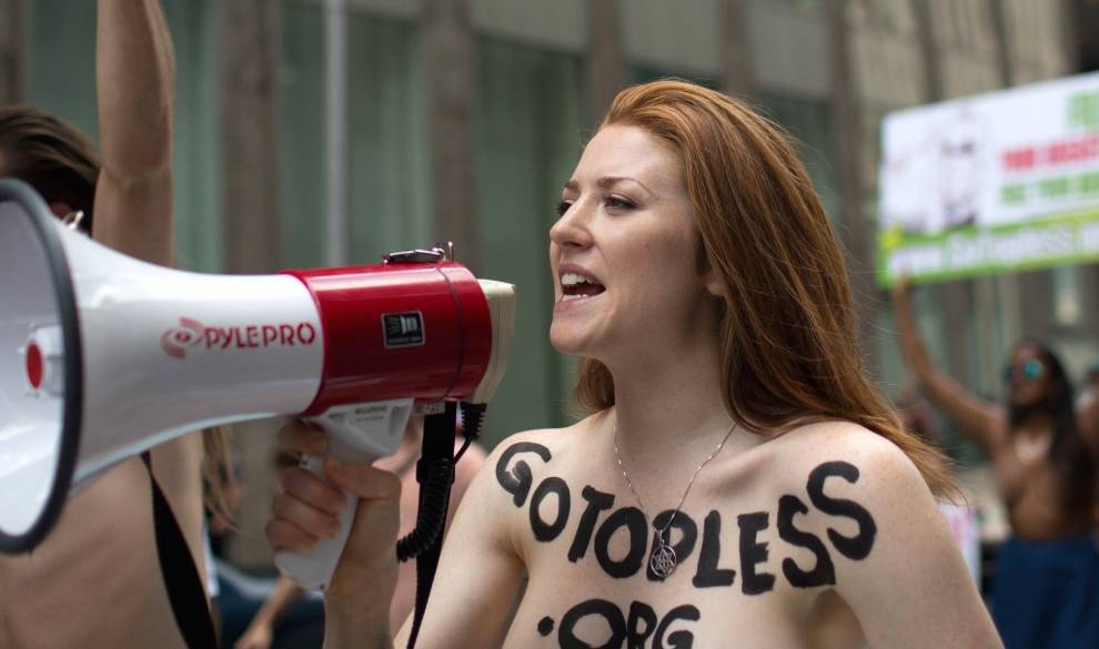 Rachel Jessee speaks into a megaphone while riding atop a car during the GoTopless Day Parade, Sunday, Aug. 23, 2015, in New York. The parade, organized by the women's advocacy group GoTopless, was meant to promote equality for women by calling attention to women's right to go bare-chested in public. (AP Photo/Kevin Hagen) $!Rachel Jessee speaks into a megaphone while riding atop a car during the GoTopless Day Parade, Sunday, Aug. 23, 2015, in New York. The parade, organized by the women's advocacy group GoTopless, was meant to promote equality for women by calling attention to women's right to go bare-chested in public. (AP Photo/Kevin Hagen)