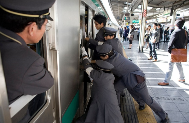 $!Las imágenes del surrealista trabajo de los ‘empujadores’ del metro de Tokio