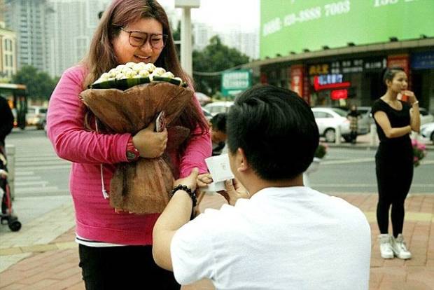 $!Pic shows: You Pan asks his girlfriend Yan Tai, 20 to marry him. A jealous boyfriend deliberately fattened up his girlfriend to put off any love rivals. Businessman You Pan, 25, met pretty Yan Tai, 20, when she only weighed just over seven stone. But after he took her out regularly for big breakfasts, lunches and dinners she ballooned in weight to a massive 14 stones. And just to be sure no one else took any interest in her, he even woke her up and fed her midnight snacks. The unusual courtship has been happening in in South Chinas Guangdong Province and has been the talk of the town ever since it was reported in local media. The story came out when after two years of dating Tou proposed to Yan, 19, with a chocolate bouquet and a promise to love her and feed her even more. She said yes and when she posted the images online, revealed the reason for the chop okay which quickly became one of the most talked about discussions on Chinese social media platforms. Neighbour Yi Chiang who has known the girl since she was little said: Its hard to believe how much weight Yan has put on but she is still very beautiful. She will make a lovely bride and Im sure they will be very happy together. I dread to think how much they have spent on food but if it makes them happy then why not. (ends)