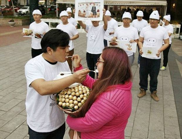 $!Pic shows: The couple after the proposal. A jealous boyfriend deliberately fattened up his girlfriend to put off any love rivals. Businessman You Pan, 25, met pretty Yan Tai, 20, when she only weighed just over seven stone. But after he took her out regularly for big breakfasts, lunches and dinners she ballooned in weight to a massive 14 stones. And just to be sure no one else took any interest in her, he even woke her up and fed her midnight snacks. The unusual courtship has been happening in in South Chinas Guangdong Province and has been the talk of the town ever since it was reported in local media. The story came out when after two years of dating Tou proposed to Yan, 19, with a chocolate bouquet and a promise to love her and feed her even more. She said yes and when she posted the images online, revealed the reason for the chop okay which quickly became one of the most talked about discussions on Chinese social media platforms. Neighbour Yi Chiang who has known the girl since she was little said: Its hard to believe how much weight Yan has put on but she is still very beautiful. She will make a lovely bride and Im sure they will be very happy together. I dread to think how much they have spent on food but if it makes them happy then why not. (ends)