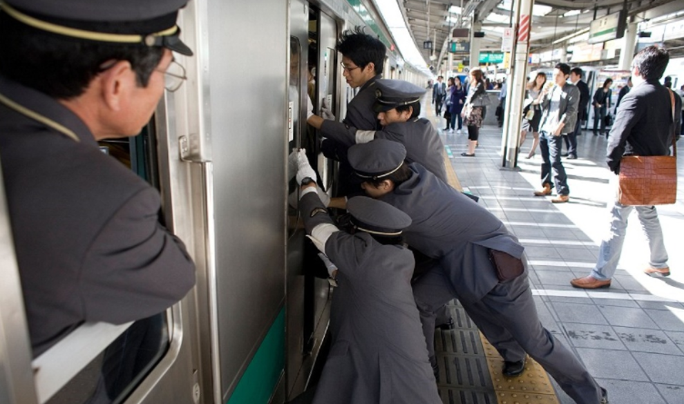 $!Las imágenes del surrealista trabajo de los ‘empujadores’ del metro de Tokio